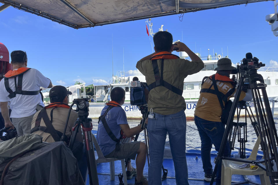 Journalists on board the Philippine coast guard ship BRP Cabra watch as a Chines coast guard vessel chases them as they approach Second Thomas Shoal, locally known as Ayungin Shoal, during a resupply mission at the disputed South China Sea on Friday Nov. 10, 2023. (AP Photo/Jim Gomez)