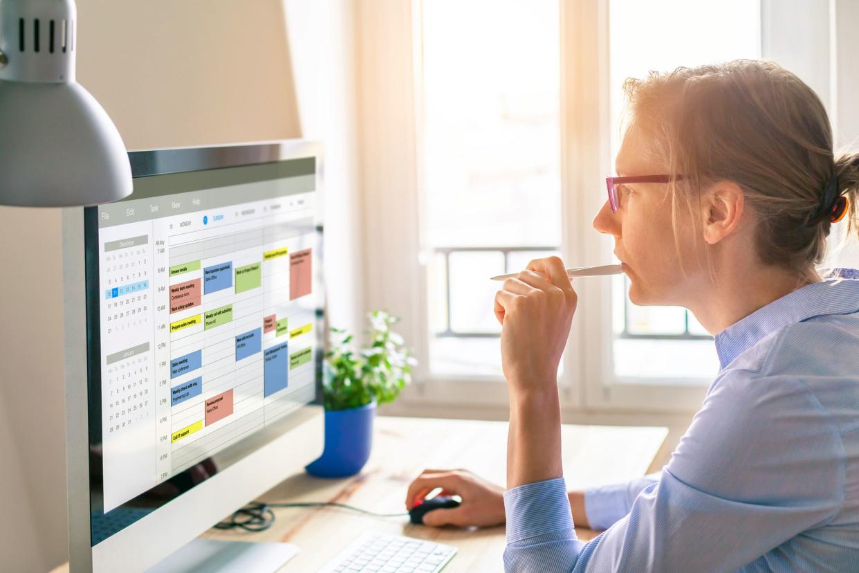 woman looking at calendar on computer in office