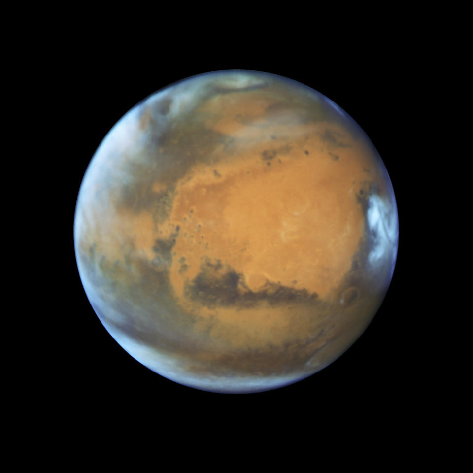 Mars as it was observed shortly before opposition in May 2016 by the Hubble Space Telescope. Some prominent features are clearly visible, including the heavily eroded Arabia Terra in the center of the image and the small