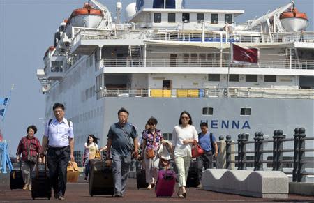 Passengers leave Chinese cruise ship Henna, which is stranded at the port of Jeju on Jeju island, south of Seoul September 15, 2013, to go to an airport to leave Jeju. REUTERS/Kim Ho-Chun/Yonhap