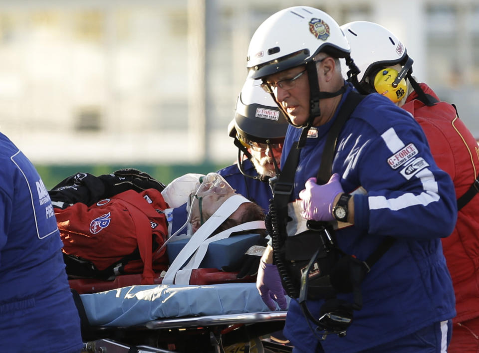 Rescue workers move driver Memo Gidley, center, to an ambulance after he was involved in a crash during the IMSA Series Rolex 24 hour auto race at Daytona International Speedway in Daytona Beach, Fla., Saturday, Jan. 25, 2014. (AP Photo/John Raoux)