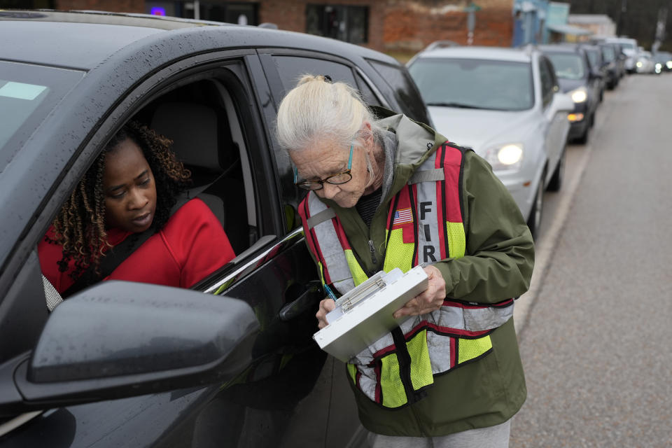 Mason resident Doricel Henley, left, registers with Celia Chastain as she waits to receive bottled water at the Mason Fire Department, Wednesday, Jan. 24, 2024, in Mason, Tenn. A winter storm brought sub-freezing temperatures and snow to Mason and the rest of Tennessee last week. The cold caused the town's pipes to freeze over and break, creating leaks that lowered water pressure. The cold exposed major problems with a water system that dates back to the 1950s. (AP Photo/George Walker IV)