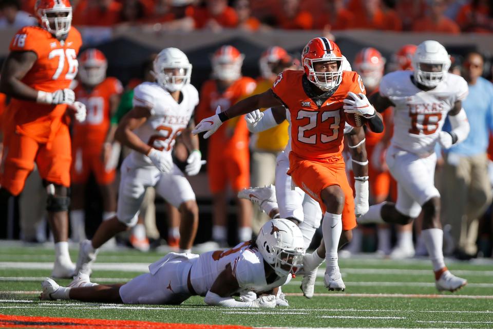 Oklahoma State running back Jaden Nixon (23) runs past Texas defensive back Jaylon Guilbeau (13) on Saturday in Stillwater.