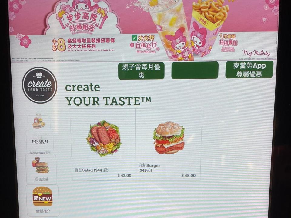 A self-order kiosk with a screen showing burger options with a pink design on top with images of fries in a container with a cartoon rabbit on them