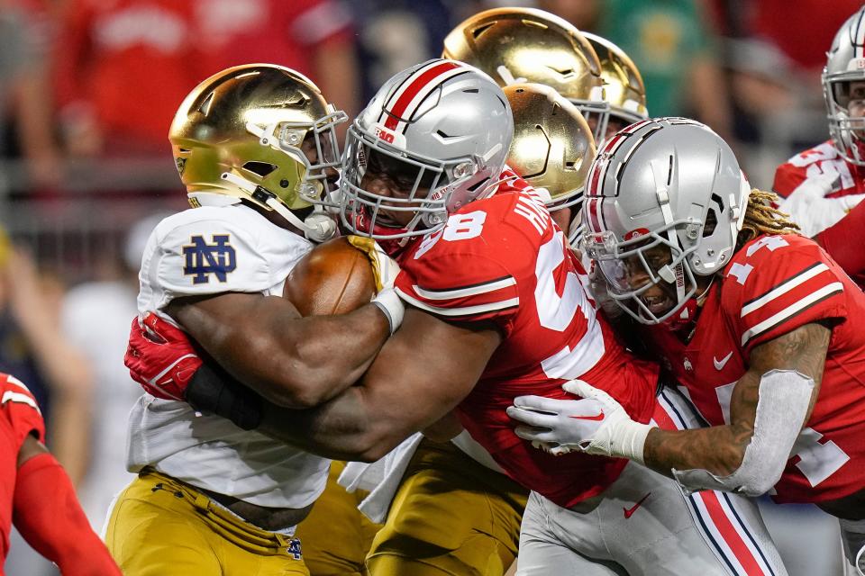 Ohio State defensive tackle Ty Hamilton tackles Notre Dame running back Audric Estime.