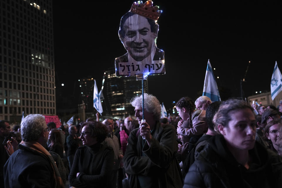 Israelis protest Israeli Prime Minister Benjamin Netanyahu, seen depicted in a placard, and his his far-right government that his opponents say threaten democracy and freedoms, in Tel Aviv, Israel, Saturday, Jan. 21, 2023. Hebrew reads: "fly chick." (AP Photo/ Oded Balilty)