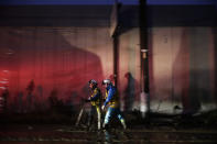 Two search and rescue team members walk along the mud-covered street Monday, Oct. 14, 2019, in Hoyasu, Japan. Rescue crews in Japan dug through mudslides and searched near swollen rivers Monday as they looked for those missing from a typhoon that left as many as 36 dead and caused serious damage in central and northern Japan. (AP Photo/Jae C. Hong)