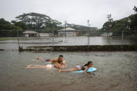 <p>Residents bodyboard in floodwaters at a baseball field during flooding from Tropical Storm Lane on the Big Island on Aug. 25, 2018 in Hilo, Hawaii. (Photo: Mario Tama/Getty Images) </p>