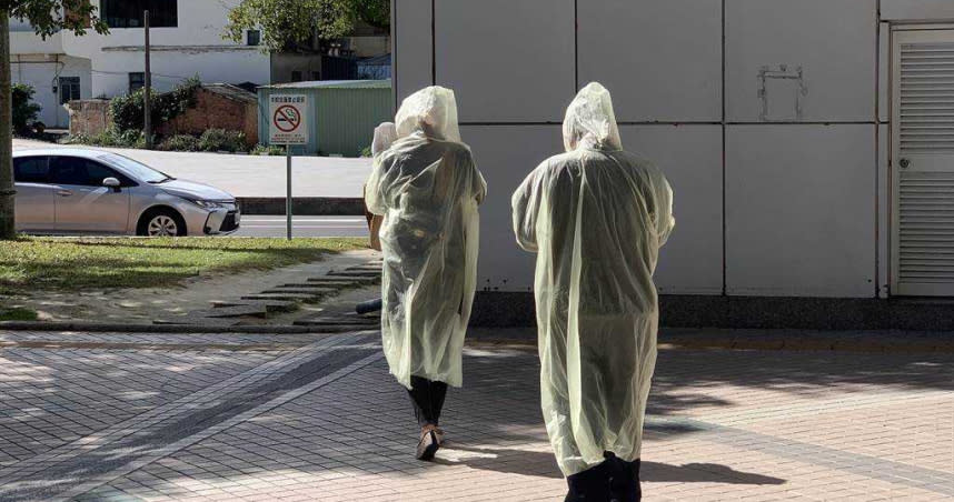 民眾身穿雨衣、戴上帽子，進入部桃領取藥物。（圖／中國時報姜霏攝）