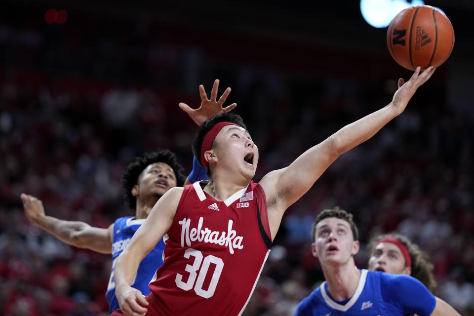 Nebraska guard Keisei Tominaga (30) drives to the basket in front of Creighton guard Trey Alexander, left, and center Ryan Kalkbrenner, right, during the first half of an NCAA college basketball game, Sunday, Dec. 3, 2023, in Lincoln, Neb. (AP Photo/Charlie Neibergall)