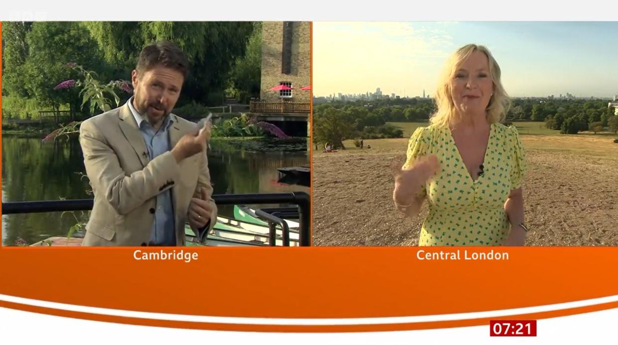 Jon Kay dabs his shoulder after being splatted with pigeon poo while presenting from Cambridge (BBC Breakfast)