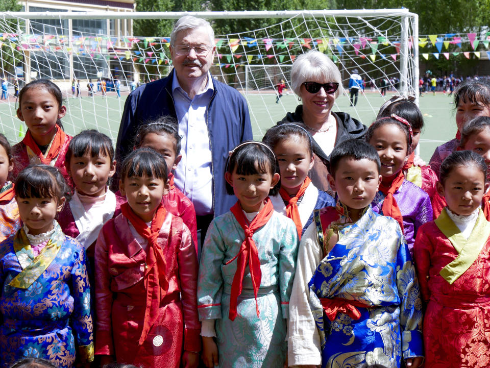 In this photo taken May 22, 2019, and released by the U.S. Embassy in Beijing, U.S. Ambassador to China Terry Branstad and his wife Christine pose for a group photo with schoolchildren as he visits an elementary school in Lhasa in western China's Tibet Autonomous Region. The U.S. ambassador to China made a rare visit to Tibet this week to meet local officials and raise concerns about restrictions on Buddhist practices and the preservation of the Himalayan region's unique culture and language. (U.S. Mission to China via AP)