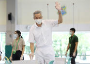 In this photo provided by Ministry of Communications and Information, Singapore Prime Minister Lee Hsien Loong waves as he casts his vote at Alexandra Primary School Friday, July 10, 2020 in Singapore. Singaporeans are voting in a general election that is expected to return Lee’s long-governing party to power. (Ministry of Communications and Information via AP)