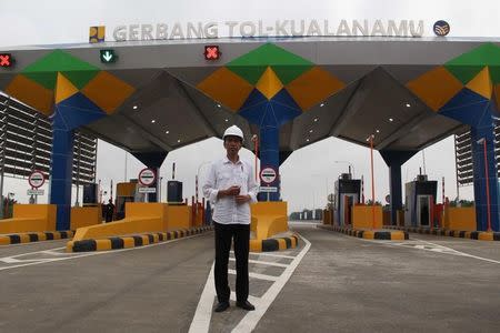 Indonesian President Joko Widodo stands in front of the gate of the Trans Sumatra toll road in Deli Serdang, North Sumatra province, Indonesia October 13, 2017. Antara Foto/Septianda Perdana via REUTERS