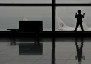 Un niño mira por la ventana a la pista, donde están varios aviones de Malaysia Airlines, en el aeropuerto internacional de la bahía de Kuala Lumpur, en Sepang, el 14 de marzo de 2014 (AFP | Manan Vatsyayana)