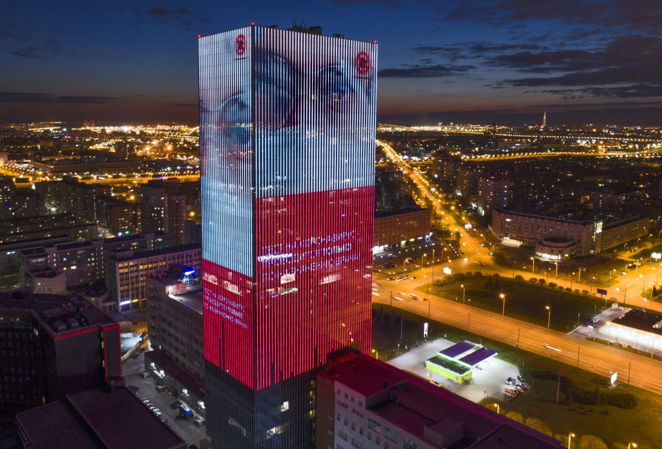 An electronic screen, installed on the facade of a business centre, shows an image of a doctor wearing a medical mask and calling to be careful not to become infected with coronavirus in St. Petersburg, Russia, Thursday, April 30, 2020. (AP Photo/Dmitri Lovetsky)