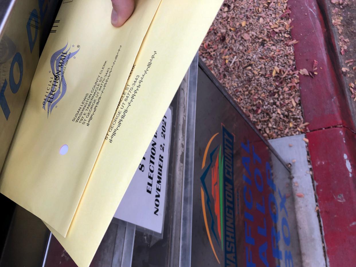 A voter drops ballots into the official ballot box outside the St. George branch of the Washington County library on Election Day, Tuesday, Nov. 2, 2021.