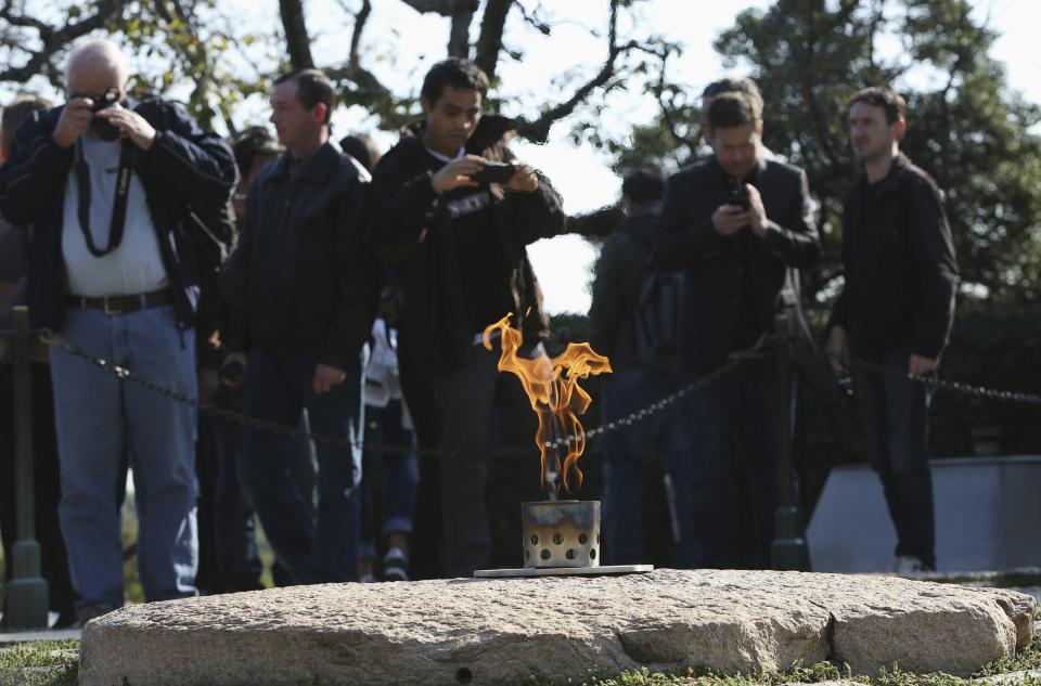 Tourists gather around new permanent eternal flame at the gravesite of former US President John F Kennedy at Arlington National Cemetery in Virginia