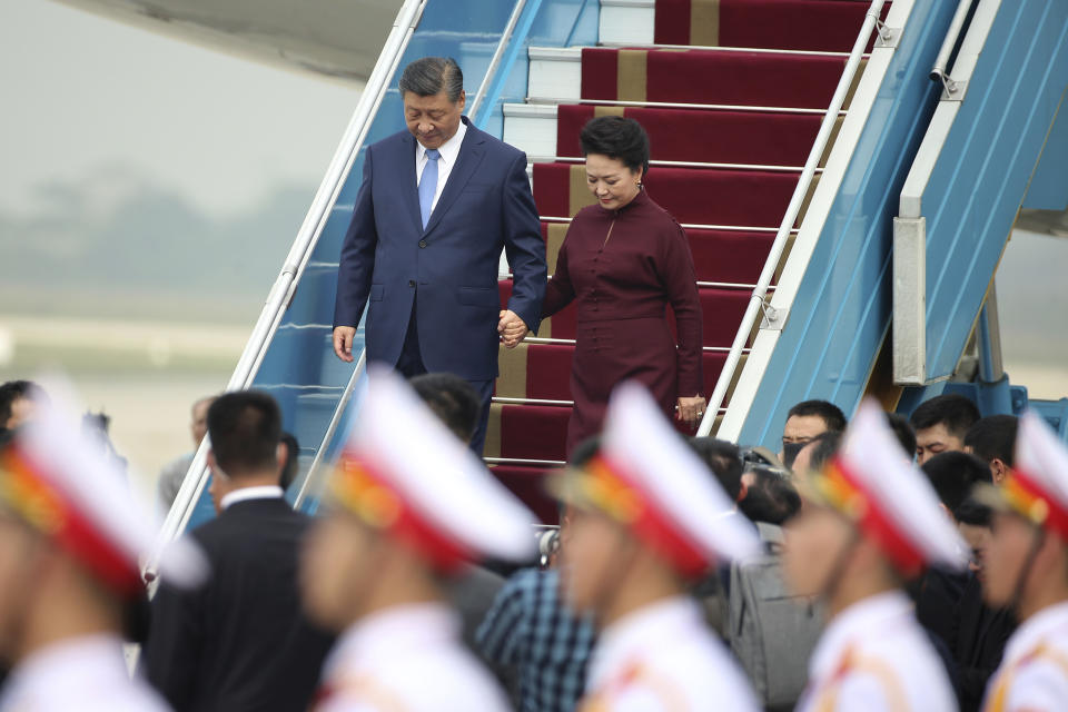 Chinese President Xi Jinping, left, and his wife Peng Liyuan, right, arrive at Noi Bai International airport in Hanoi, Vietnam, Tuesday, Dec. 12, 2023. Chinese leader Xi arrived in Vietnam on Tuesday seeking to further deepen ties with the Southeast Asian nation, weeks after it elevated its diplomatic relations with Western-aligned countries. (Luong Thai Linh/Pool Photo via AP)