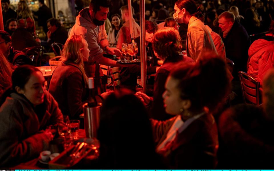 A waiter serves a tray of drinks on Old Compton Street in Soho - Rob Pinney/Getty Images