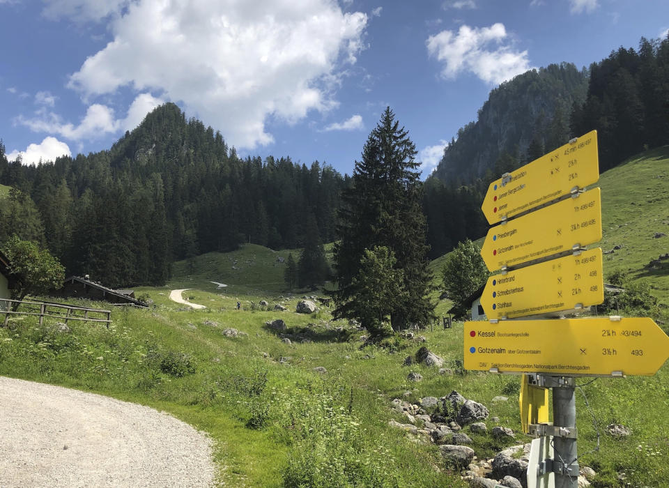 Signposts that provide estimated hiking times and degrees of difficulty appear along a trail in the Berchtesgaden National Park in Germany on June 27, 2022. (AP Photo/Mike Eckel)