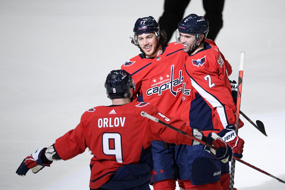 Washington Capitals right wing T.J. Oshie (77) celebrates his goal with defenseman Justin Schultz (2) and defenseman Dmitry Orlov (9) during the third period of an NHL hockey game New York Rangers, Sunday, March 28, 2021, in Washington. (AP Photo/Nick Wass)