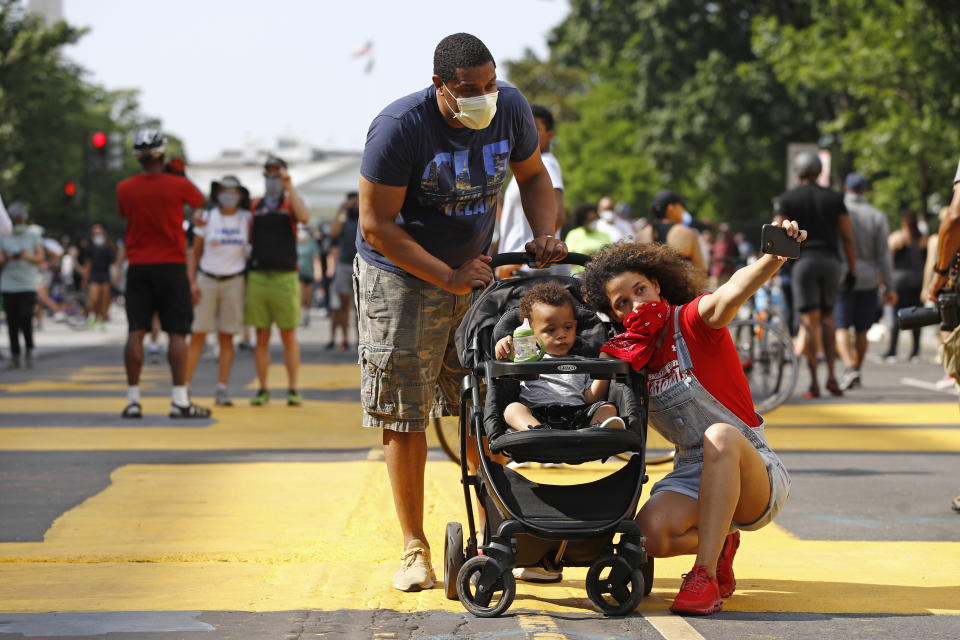 Katie Williams, right, poses for a photo with her son Benjamin, 18 months, and husband Kyle near the White House, Saturday, June 6, 2020, in Washington, as people gather before scheduled protests over the death of George Floyd, who died after being restrained by Minneapolis police officers. (AP Photo/Patrick Semansky)