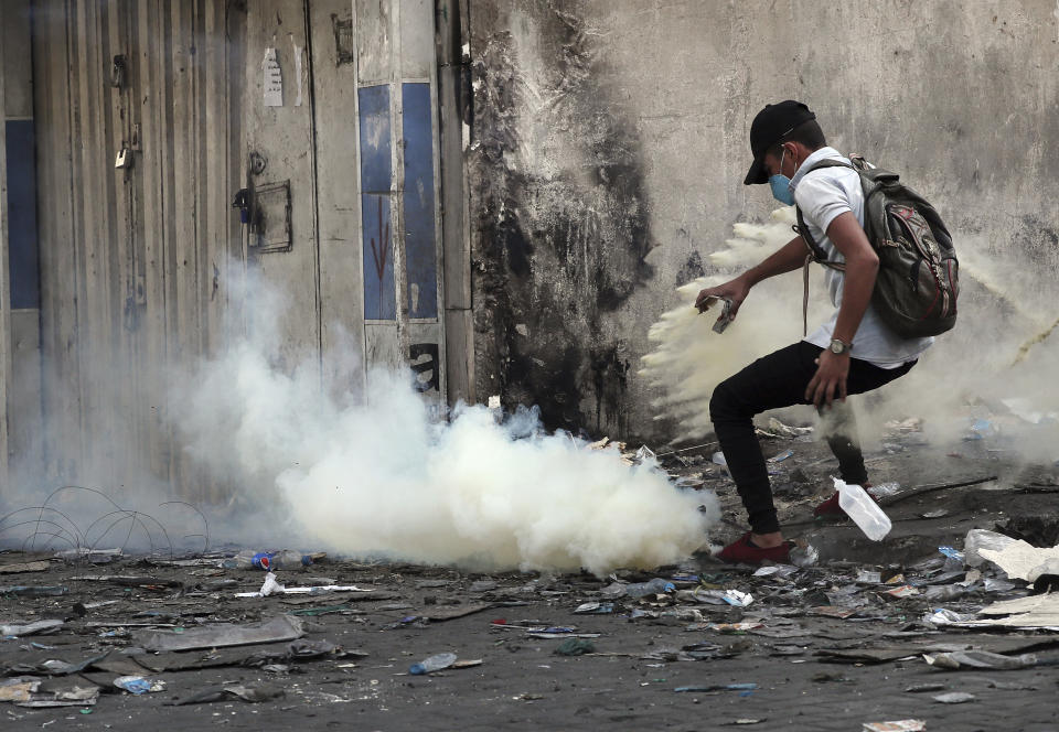 Riot police fire tear gas during clashes between Iraqi security forces and anti-government demonstrators, in downtown Baghdad, Iraq, Wednesday, Nov. 13, 2019. (AP Photo/Hadi Mizban)