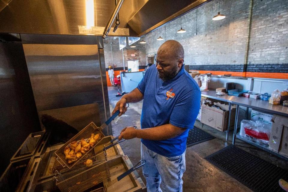 Thomas Williams, the owner of Wing KYng, works to make wings in the kitchen of his storefront at Greyline Station. He used to be carryout only from the commercial kitchen inside Southland Bagel. Silas Walker/swalker@herald-leader.com
