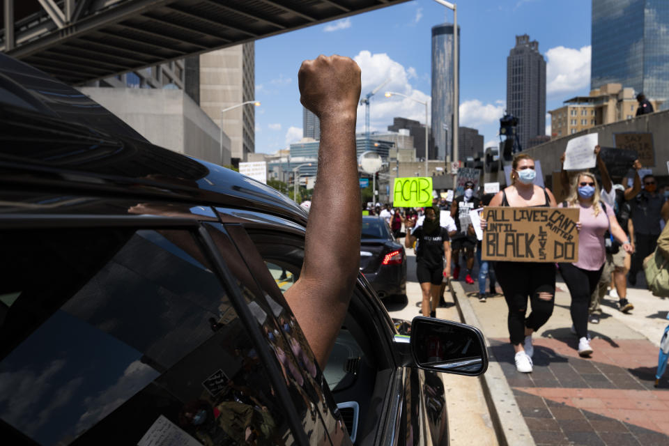 Protesters get support from a passengers of a cars they march past CNN during a demonstration over the death of Floyd, Saturday, June 13, 2020 in Atlanta. (John Amis/Atlanta Journal-Constitution via AP)