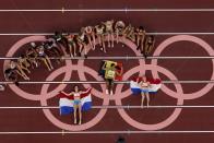 The athletes fropm the women's heptathlon pose for a picture on the Olympic rings at the 2020 Summer Olympics, Thursday, Aug. 5, 2021, in Tokyo. (AP Photo/Morry Gash)