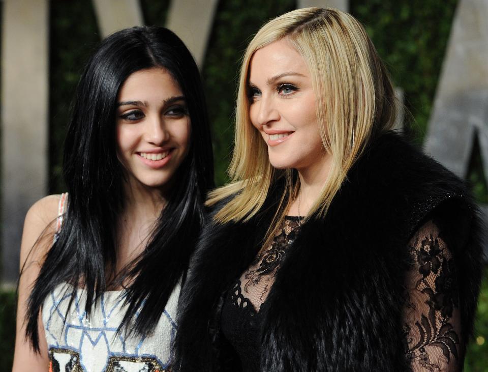 A young Lourdes smiles while looking at her mom at an event