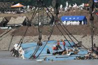 Rescuers work on righting the capsized cruise ship Eastern Star during a media trip to the site of the sinking, organised by the Chinese government, in the Jianli section of Yangtze River, Hubei province China, June 5, 2015. The death toll from a Chinese cruise ship that capsized on the Yangtze River climbed to 97 on Friday as authorities righted the battered vessel and turned their efforts to recovering bodies still on board amid simmering anger from distraught families. (REUTERS/Aly Song)