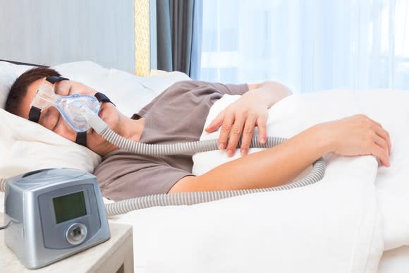 Person sleeping with CPAP machine on face