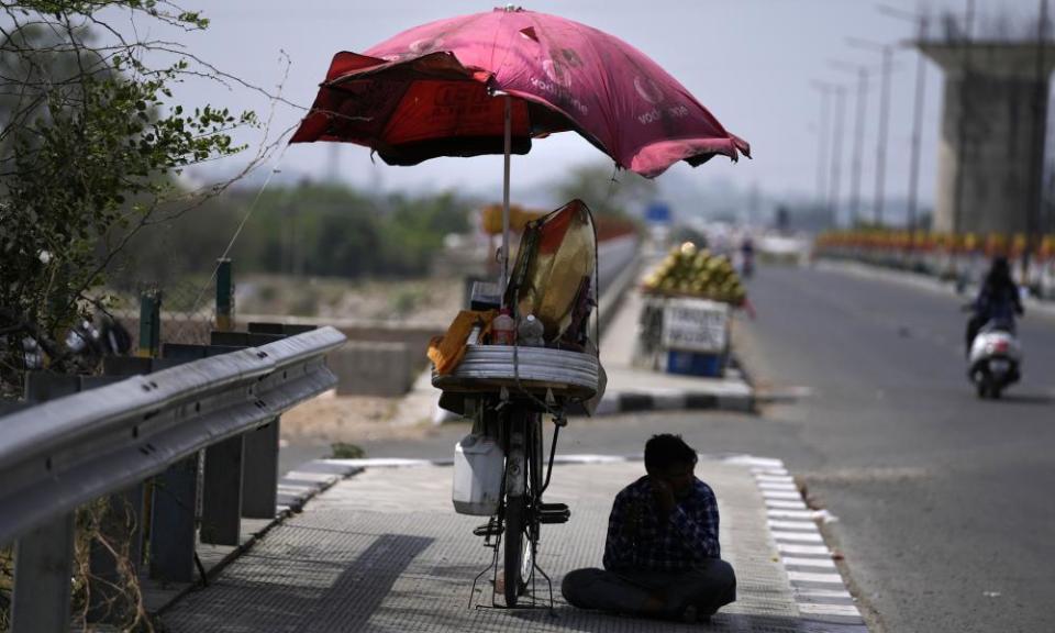 A snacks vendor sits under a shade and waits for customer on a hot summer afternoon in Jammu, India, May 19, 2022. Many parts of north west and central India continued to experience heat wave conditions. (AP Photo/Channi Anand)