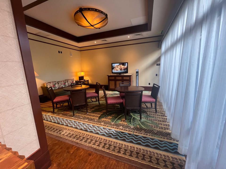 A room with tables and chairs, a couch, a TV.