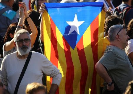 A Catalan separatist flag is held up at a demonstration organised by Catalan pro-independence movements ANC (Catalan National Assembly) and Omnium Cutural, following the imprisonment of their two leaders Jordi Sanchez and Jordi Cuixart, in Barcelona, October 21, 2017. REUTERS/Ivan Alvarado