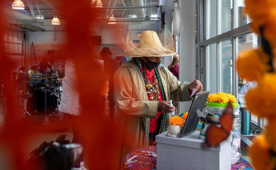 Helen Gentry leaves a note she wrote to a deceased loved one during a Dia de los Muertos event organized by the Detroit Riverfront Conservancy at the Robert C. Valade Park in Detroit on Saturday, Oct. 28, 2023.