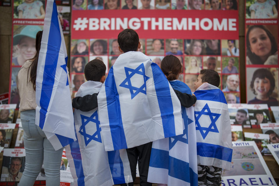 FILE - Children look at photographs of kidnapped Israelis during a rally joined by hundreds in solidarity with Israel and those held hostage in Gaza, in Bucharest, Romania, on Nov. 2, 2023. Antisemitism is spiking across Europe after Hamas' Oct. 7 massacre and Israel's bombardment of Gaza, worrying Jews from London to Geneva and Berlin. (AP Photo/Vadim Ghirda, File)