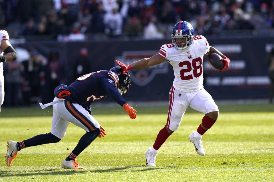 New York Giants running back Devontae Booker, (28) carries the ball as Chicago Bears safety Deon Bush comes in for the tackle during the first half of an NFL football game Sunday, Jan. 2, 2022, in Chicago. (AP Photo/Nam Y. Huh)