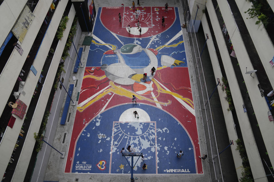 People play basketball on a court painted with the FIBA Basketball World Cup theme Thursday, Aug. 17, 2023, in Taguig city Philippines. Basketball's World Cup starts on Friday, Aug. 25. Basketball is a passion in the Philippines, and that might be putting it lightly. There are about 25,000 indoor courts in the country, countless outdoor courts — they're everywhere, with rims even fashioned out of barbed wire in some places. (AP Photo/Aaron Favila)