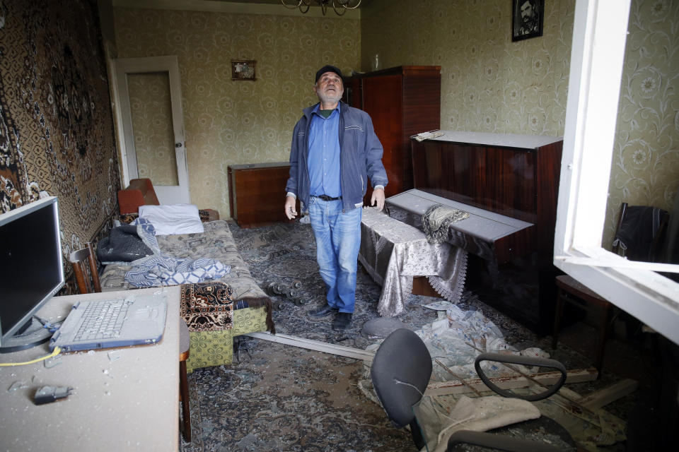 Eduard Chechyan examines damage of his flat after shelling by Azerbaijan's artillery during a military conflict in Stepanakert, the separatist region of Nagorno-Karabakh, Saturday, Oct. 10, 2020. Armenia and Azerbaijan have agreed to a Russia-brokered cease-fire in Nagorno-Karabakh after two weeks of heavy fighting that marked the worst outbreak of hostilities in the separatist region in more than a quarter-century. (AP Photo)