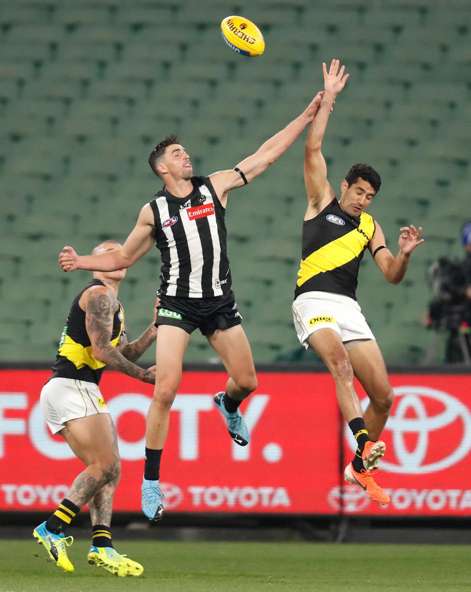 Scott Pendlebury (pictured left) and Marlion Pickett (pictured right) jump for the ball.