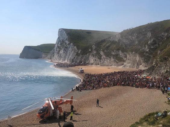 An air ambulance lands on the beach at Durdle Door as the is evacuated (PA)