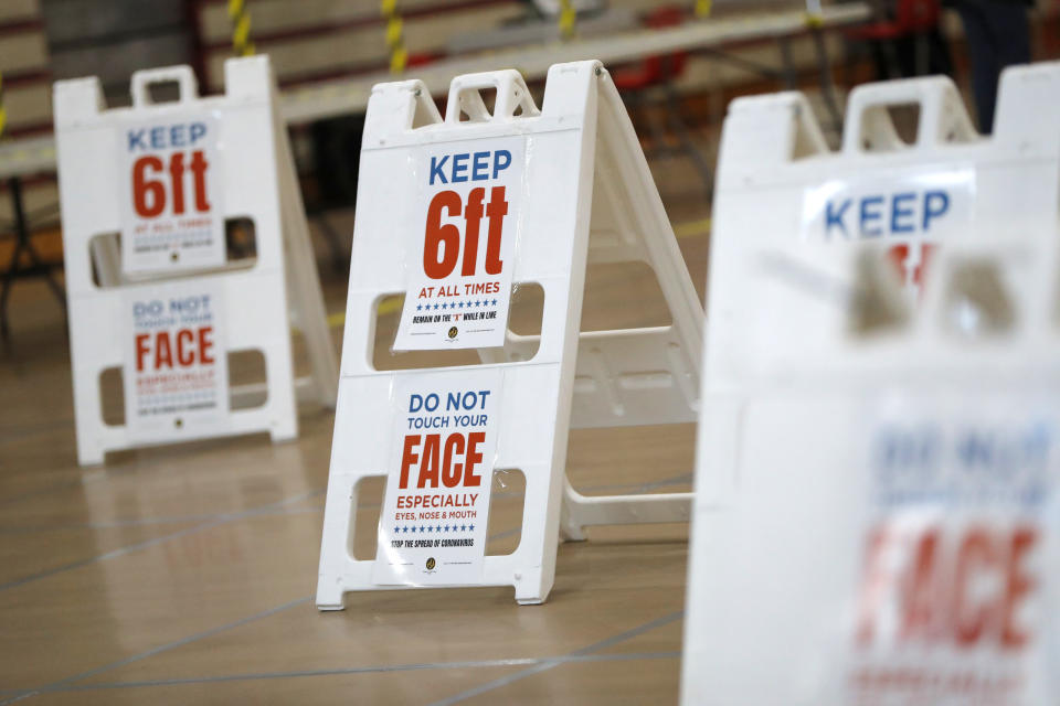 Signs are seen inside a polling center ahead of the 7th Congressional District special election at Edmondson High School, Monday, April 27, 2020, in Baltimore. Democrat Kweisi Mfume and Republican Kimberly Klacik won special primaries for the Maryland congressional seat that was held by the late Elijah Cummings. The high school is one of three places where residents will be allowed to vote in person in an effort to contain the spread of the new coronavirus. (AP Photo/Julio Cortez)
