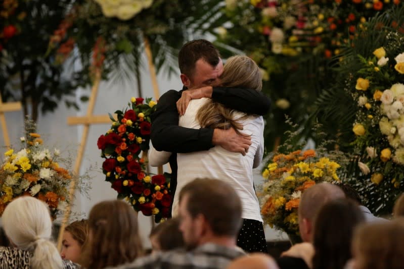 Tyler Johnson, husband of Christina Marie Langford Johnson, who was killed by unknown assailants, hugs a relative during her funeral service, before a burial at the cemetery in LeBaron, Chihuahua