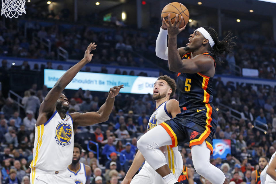 Oklahoma City Thunder guard Luguentz Dort (5) prepares to shoot as Golden State Warriors guard Klay Thompson, middle, and forward Draymond Green, left, defend during the first half of an NBA in-season tournament basketball game Friday, Nov. 3, 2023, in Oklahoma City. (AP Photo/Nate Billings)