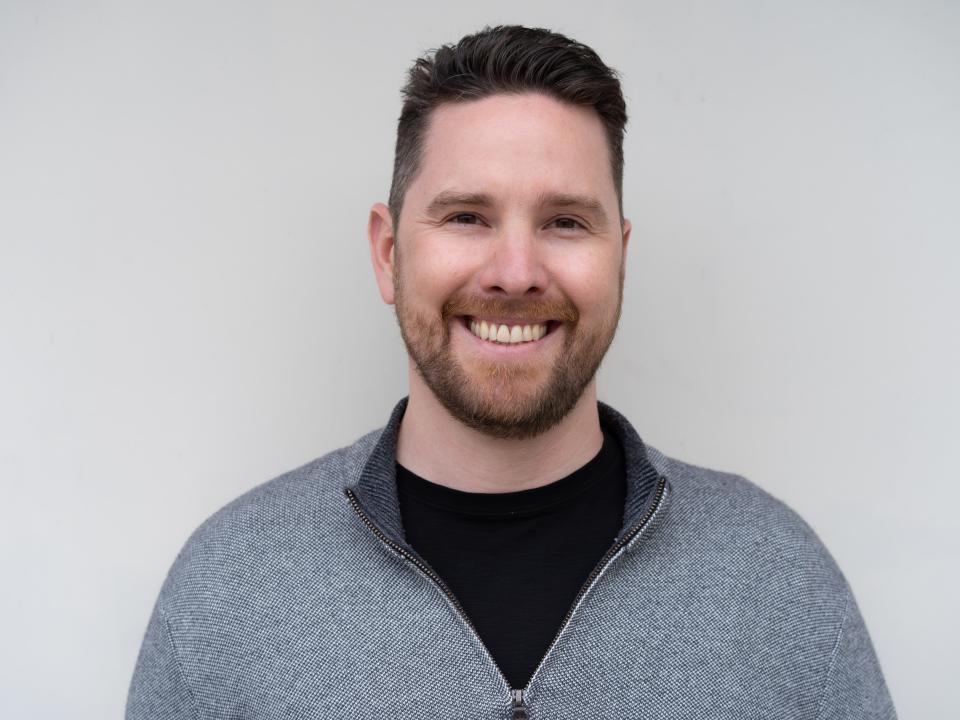 Nick Allen, Founder & CEO of Sunnyside, headshot wearing a black t-shirt and a gray zip-up sweater