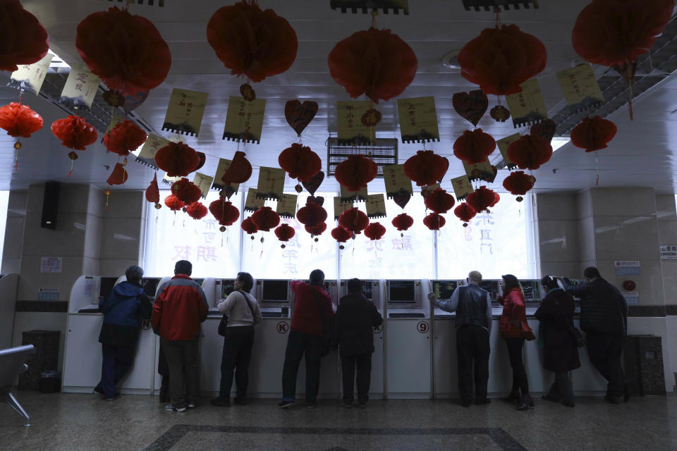 Investors monitor stock prices at a brokerage in Beijing, China, Thursday, Feb. 21, 2019. Asian stock markets were little-changed Thursday following a listless day on Wall Street ahead of U.S.-Chinese negotiations aimed at ending a tariff battle. (AP Photo/Ng Han Guan)