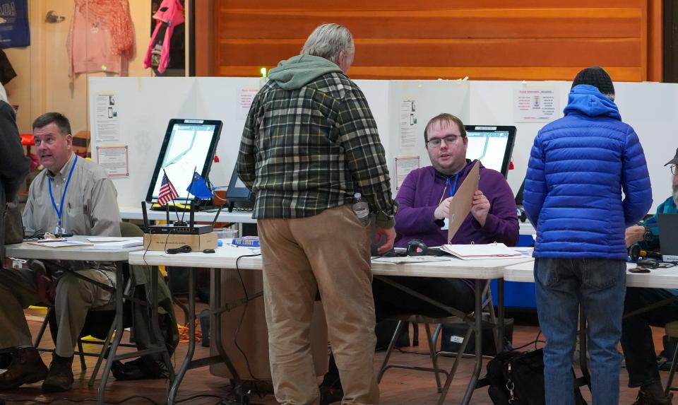 An election worker checks in a voter at a voting site in south Reno, Nevada, during the Feb. 6 presidential preference primary.